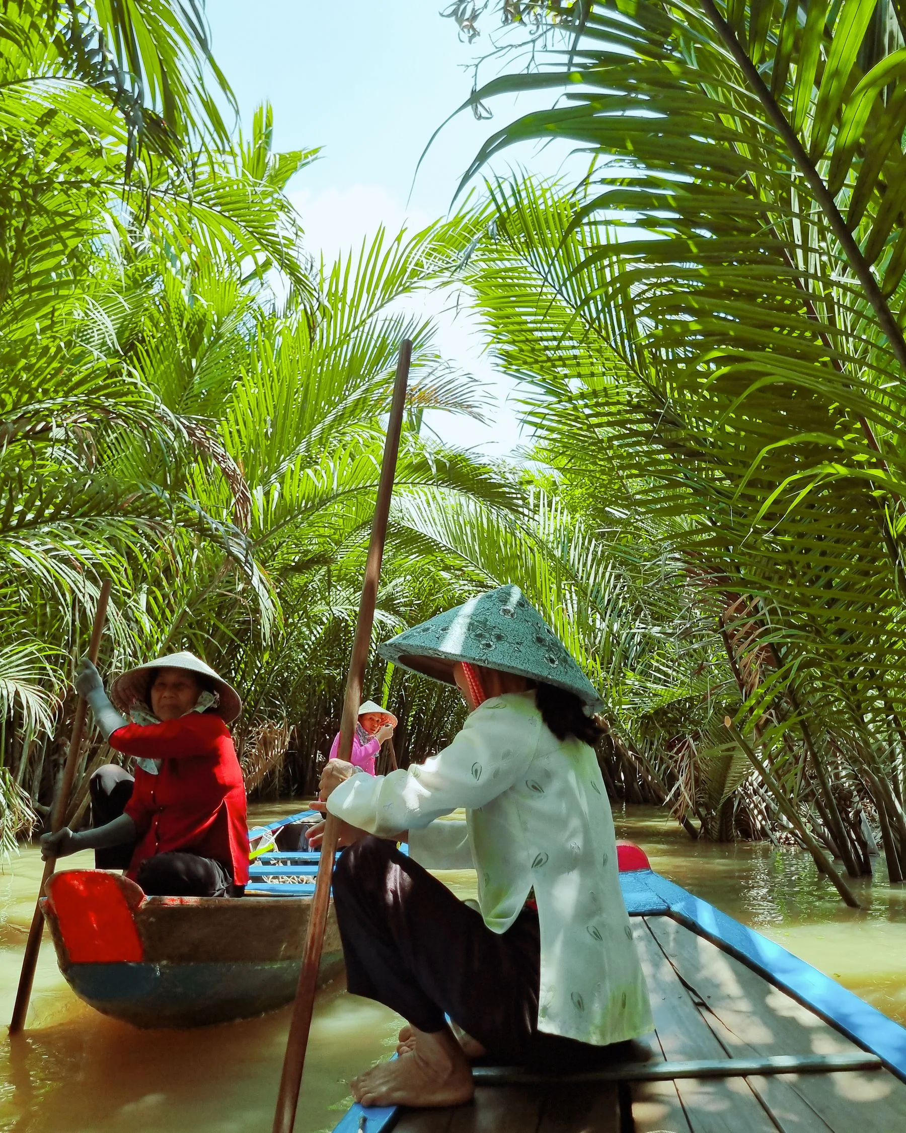 A boat moving through nipa palms in the Mekong Delta